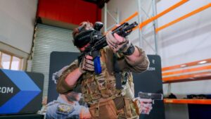 Image of Australian soldier holding a long arm rifle integrated with Operator XR system, and wearing Operator XR VR headset.